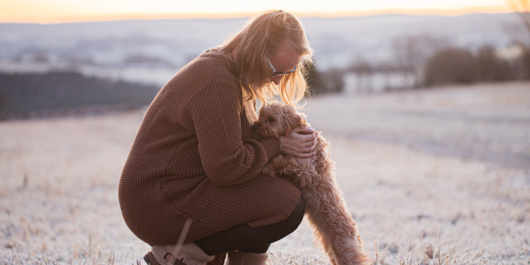 Life Coach mit Cavapoo bei einem Spaziergang im warmen Abendlicht